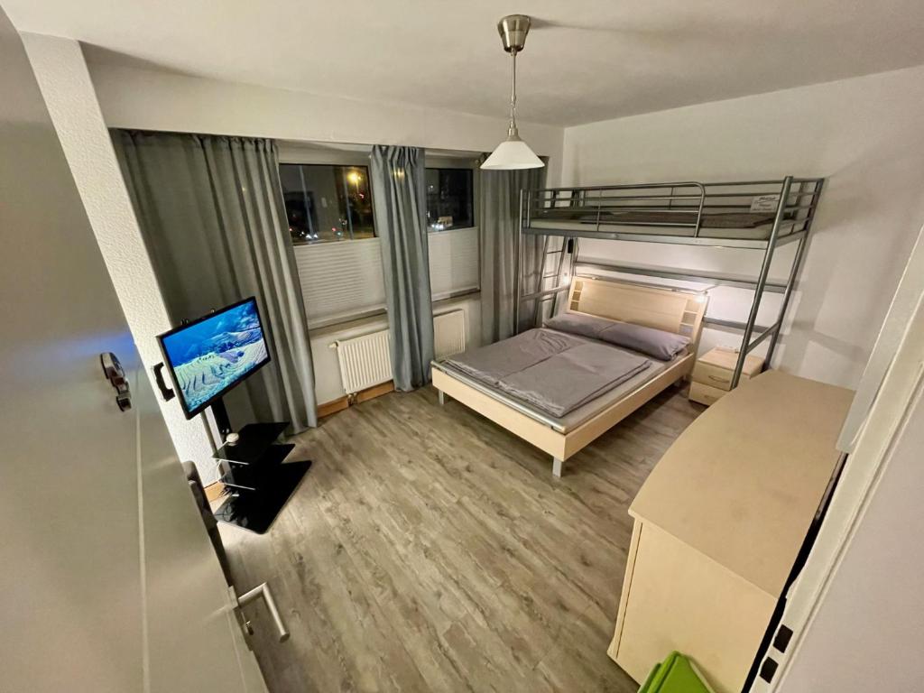 比勒费尔德WinWin im Westen的一间小卧室,配有双层床和电视