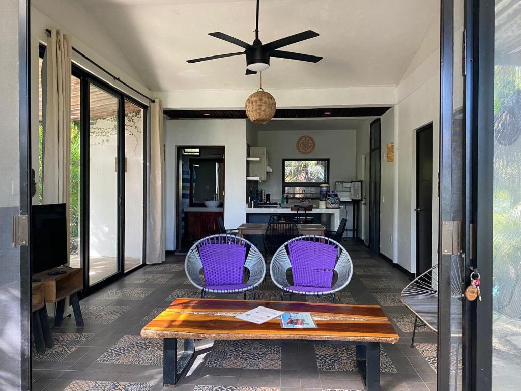 巴卡拉尔AMACA Bacalar的客厅配有桌子和紫色椅子