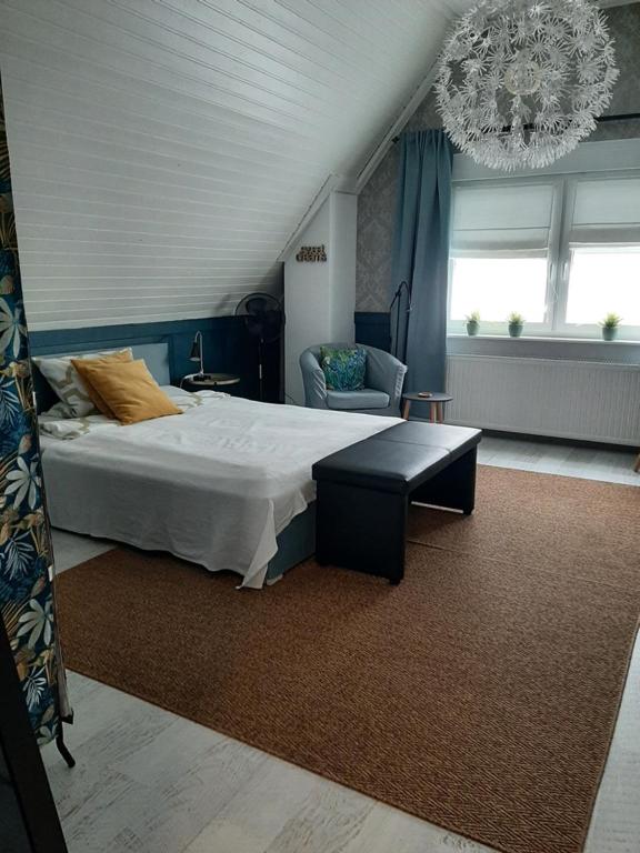 萨尔路易斯Saarlouis, Ortsteil Beaumarais "Anna's Cottage"Bed&Breakfast "#TravellerAwards 2022"的一间卧室配有一张大床和一个吊灯。