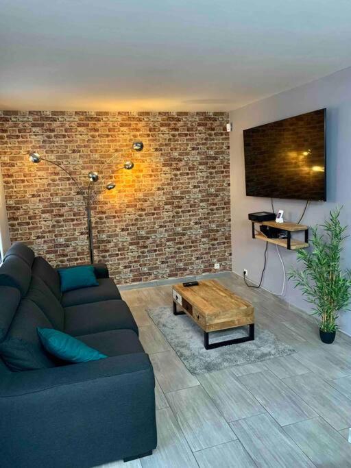 勒阿弗尔Maison avec terrasse au Havre的带沙发和砖墙的客厅