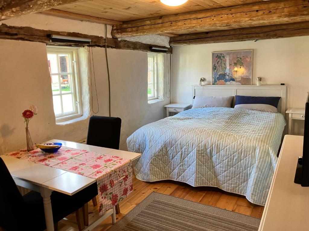 斯凯拜克Fæbrogaard Apartment的一间卧室配有一张床、一张桌子和两个窗户