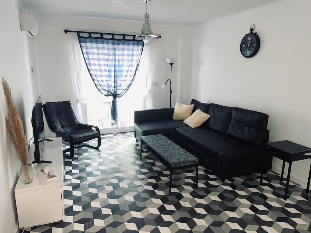 甘迪亚Apartamento Layla - solo familias的客厅配有黑色沙发和椅子