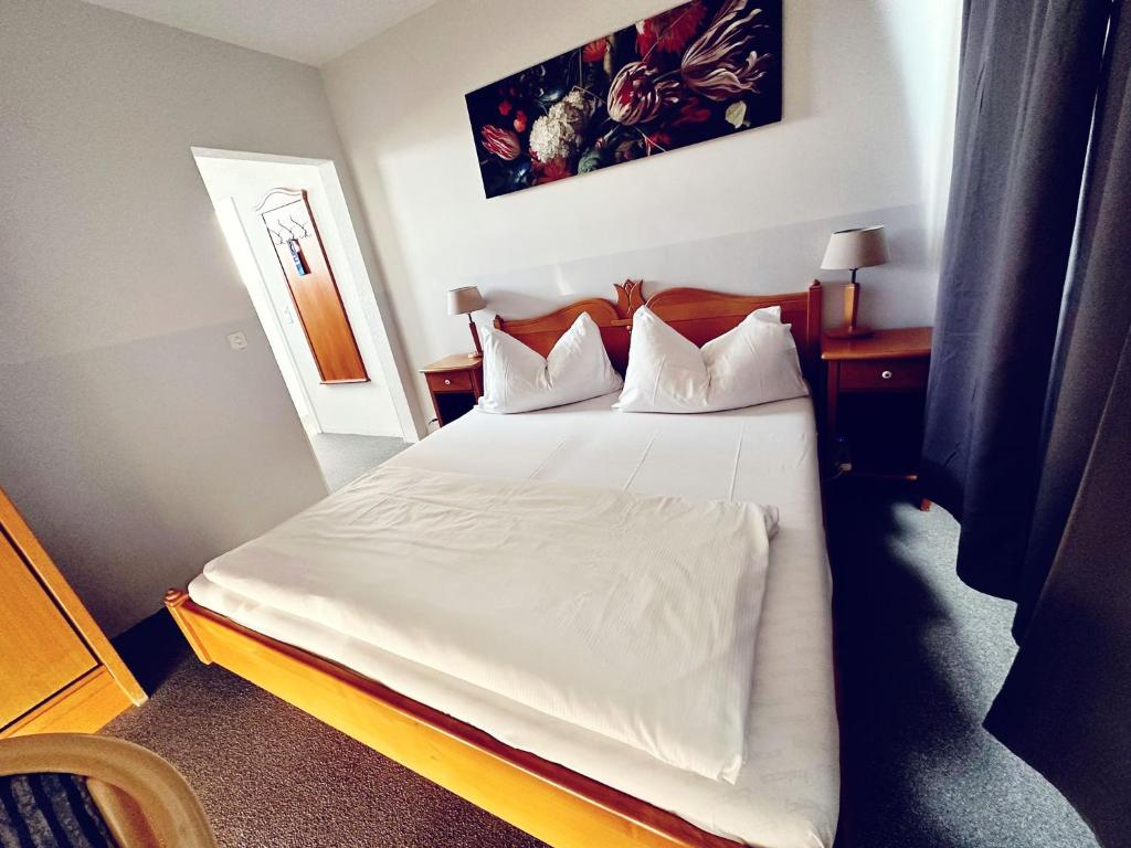 诺伊豪森日艾法尔酒店的一间卧室配有带白色床单和枕头的床。