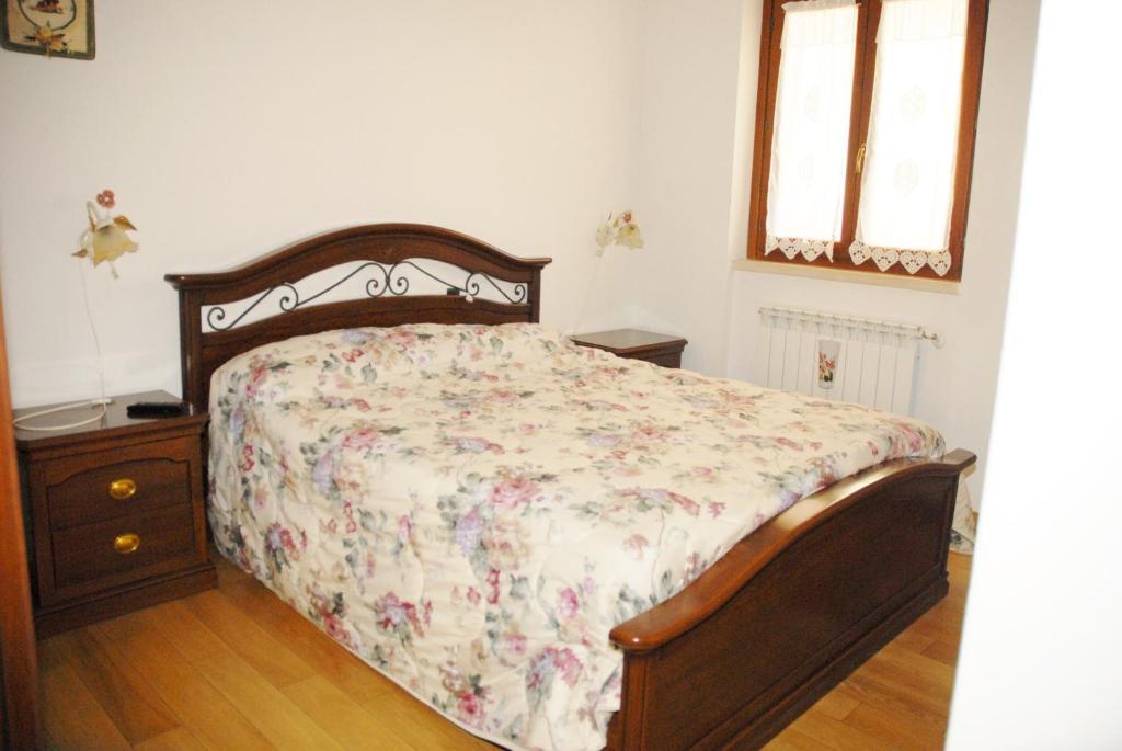 佩斯卡塞罗利Casetta a Pescasseroli的一间卧室配有一张床、一个梳妆台和两个窗户。