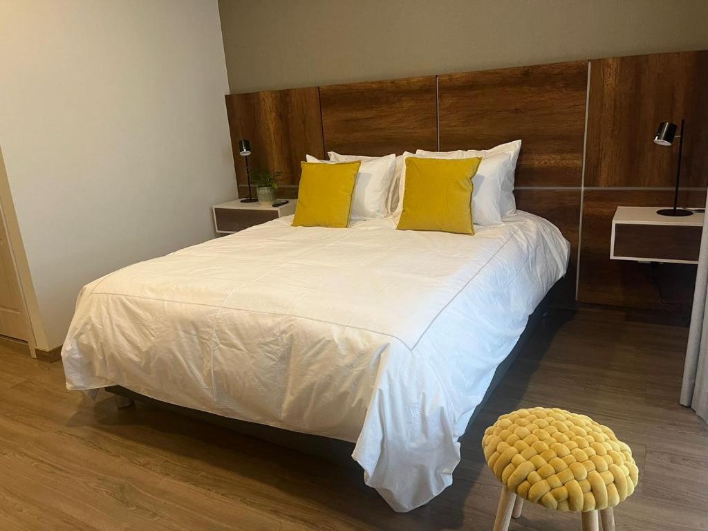 科恰班巴Gratus的一间卧室配有一张带黄色枕头的大床