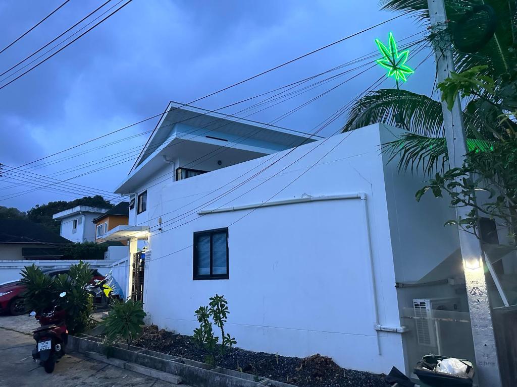 苏梅岛Infinity Bo Put Apartment的前面有棕榈树的白色房子