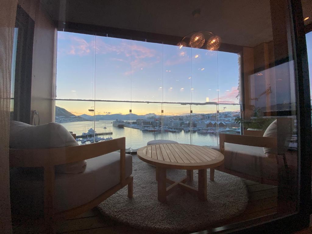 特罗姆瑟Vindlys Luxury Penthouse Apartment的客房设有大窗户,享有海港的景色