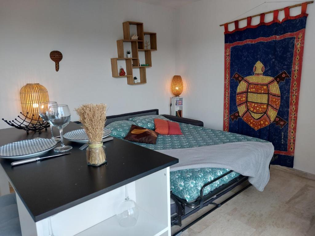 曼德琉-拉纳普勒Studio Golf Riviera - Axelle Loc'Appart的一间卧室配有一张带桌子和台面的床