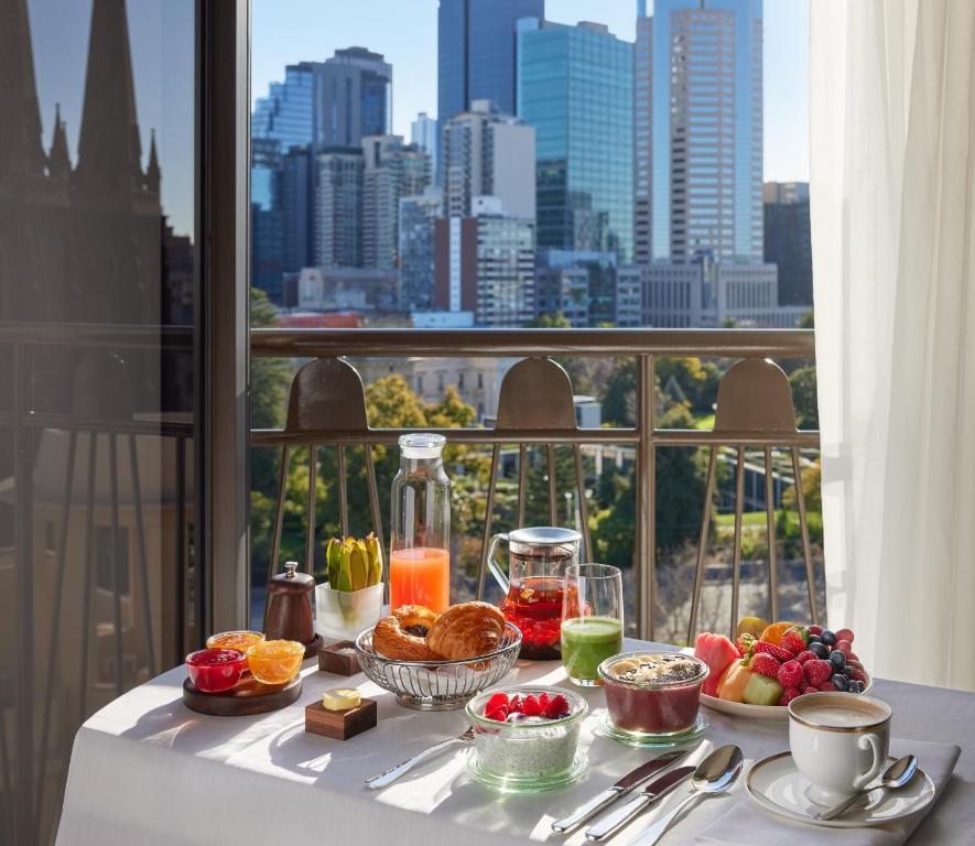 墨尔本墨尔本柏悦酒店的一张桌子,上面放着食物,享有城市美景