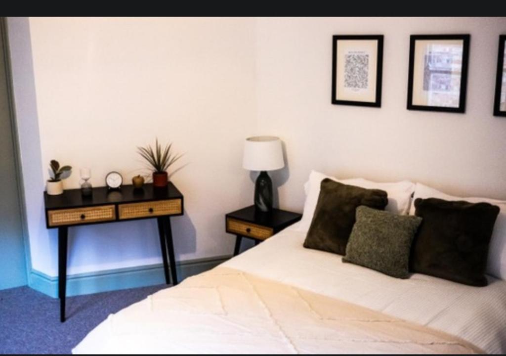 金斯林The White Hart的一间卧室配有一张床和一张带台灯的桌子