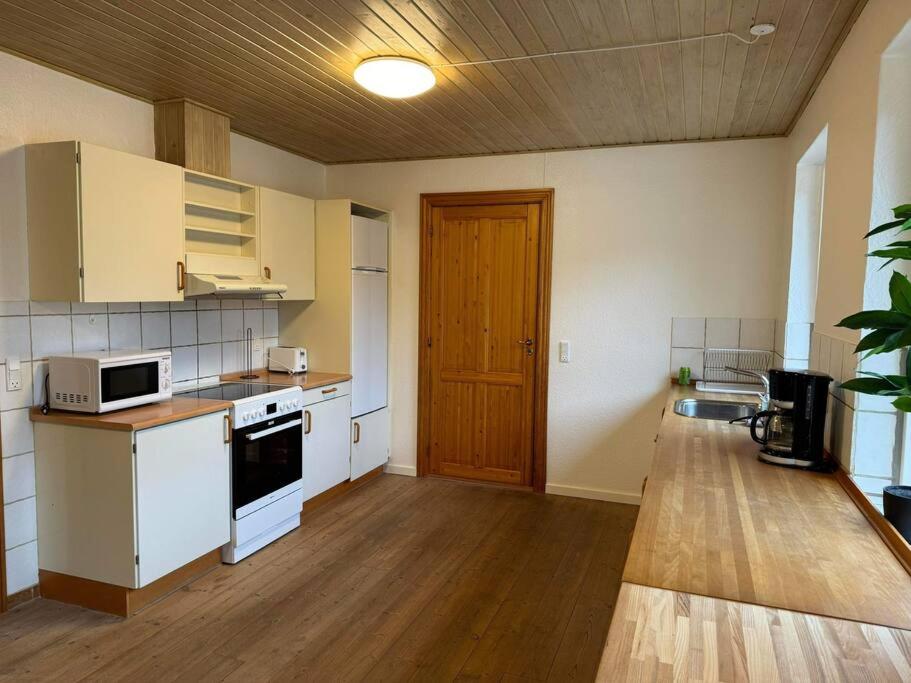 比伦德House in Billund的铺有木地板的厨房配有白色家电
