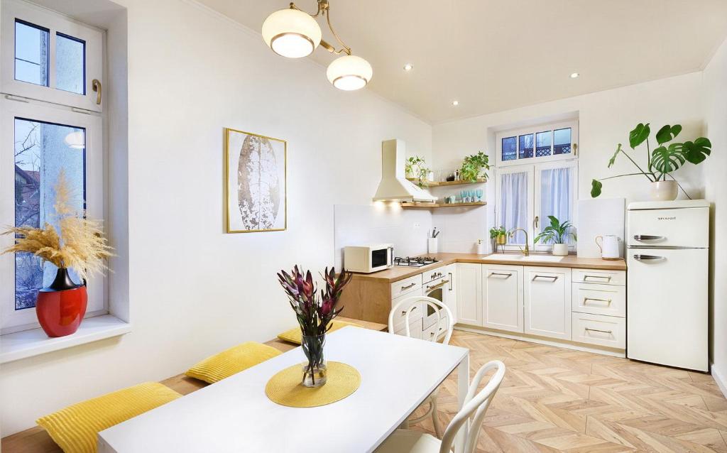 凯日马罗克Bonton Apartments的厨房配有桌椅和白色冰箱。
