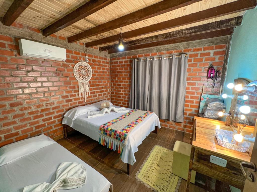博尼图Pousada Taruma Challes 02的一间卧室设有一张床和砖墙