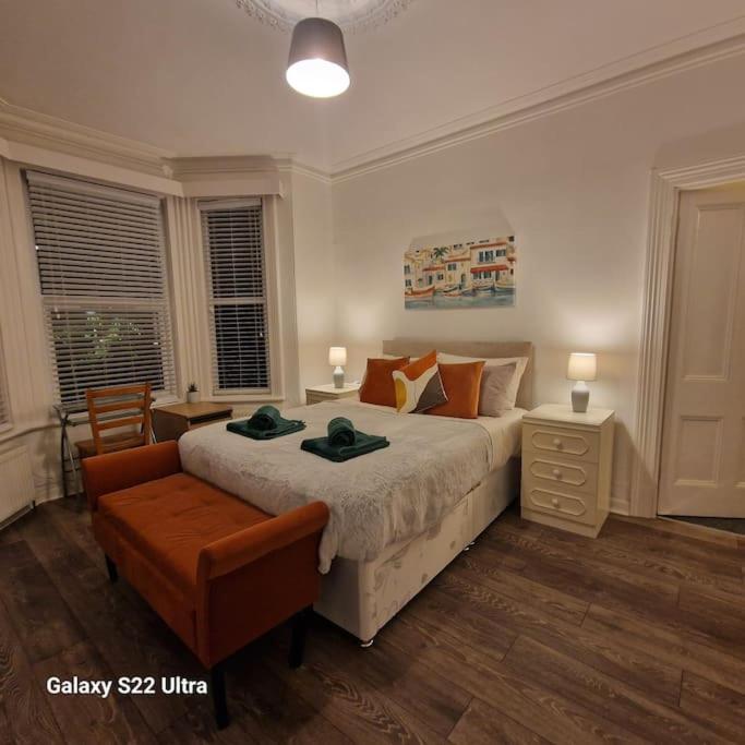普里茅斯4 Bed Park View House-Free Parking - Sleep 8的一间卧室配有一张大床和一把椅子