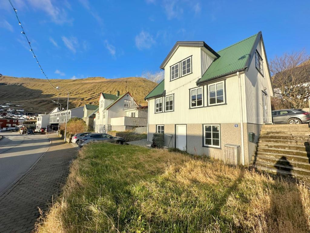 FuglafjørðurHouse in Fuglafjørður的街上有绿色屋顶的白色房子