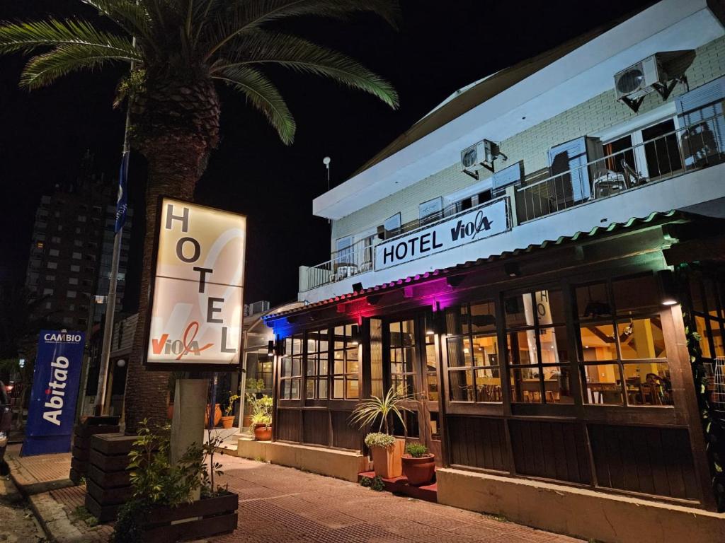 拉帕洛马Hotel Viola的一座酒店,在一座建筑前有棕榈树