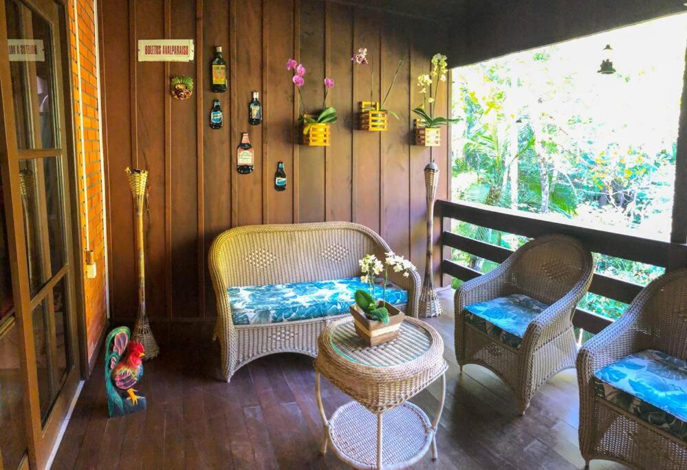 加斯帕Casa de campo com cachoeira no quintal的一个带藤椅和桌子的门廊