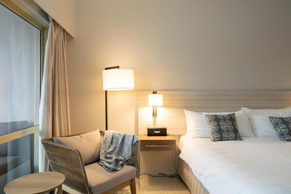 Mindarie明达里滨海酒店的配有床、椅子和桌子的酒店客房