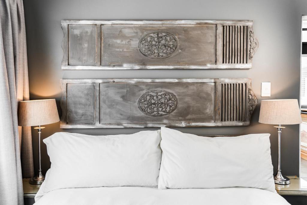 斯泰伦博斯Avemore Eikehof No 26的一间卧室配有一张带两盏灯和床头板的床。