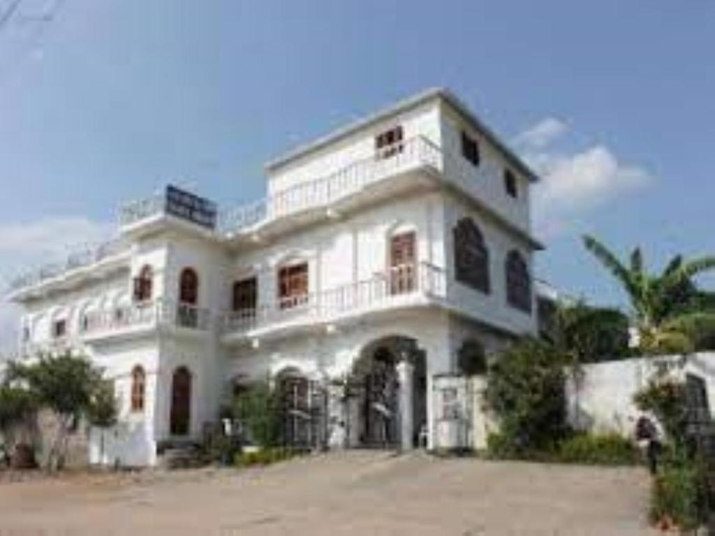 克久拉霍Hotel Isabel Palace, Khajuraho的一座大型白色建筑,上面设有阳台