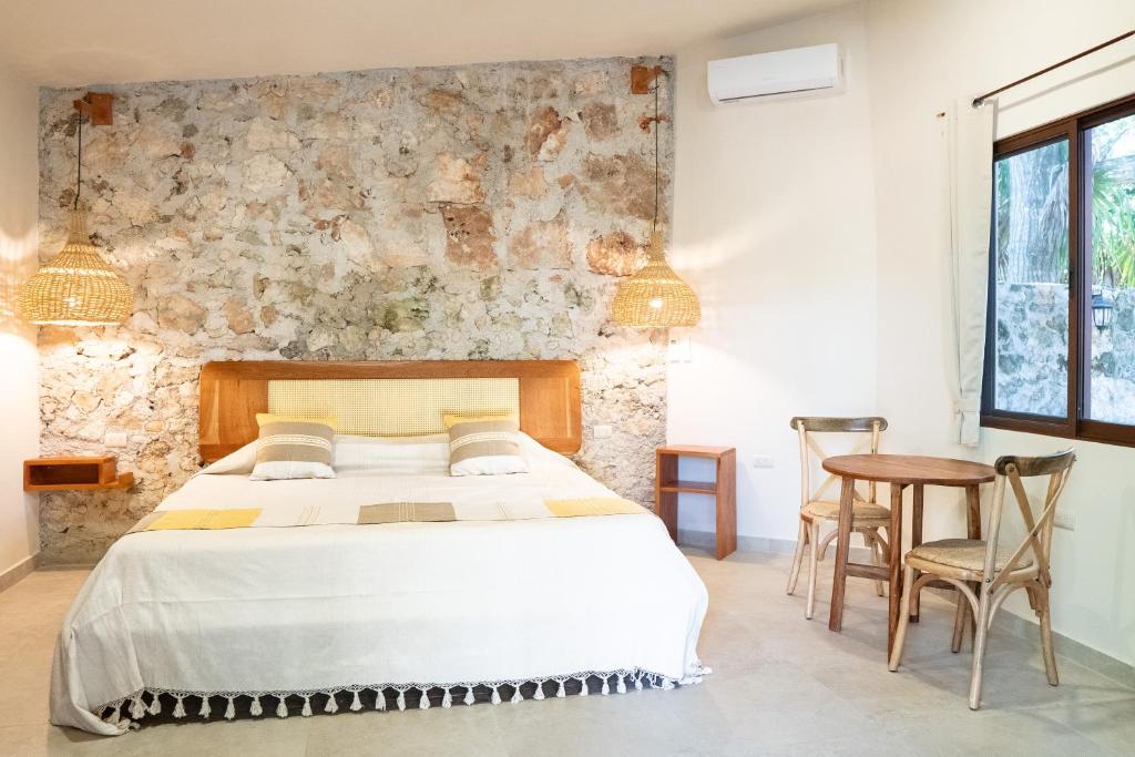 巴卡拉尔Casa Cactus Buenavista的一间卧室设有一张床和石墙