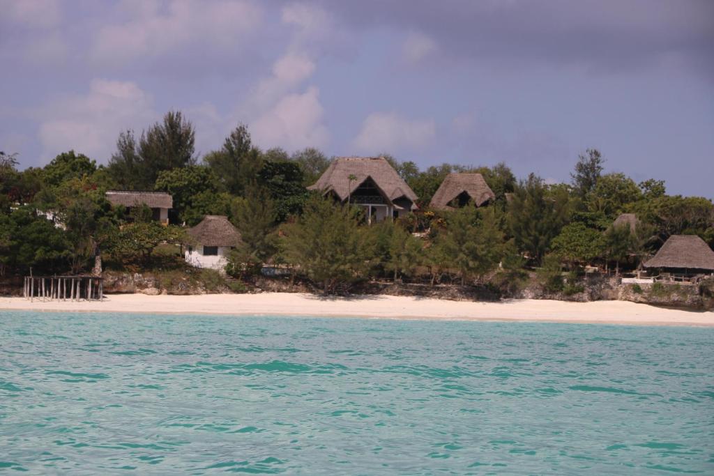 南威Sazani Beach Lodge and Tidal Lounge的海洋上的一个岛上的一组简易别墅