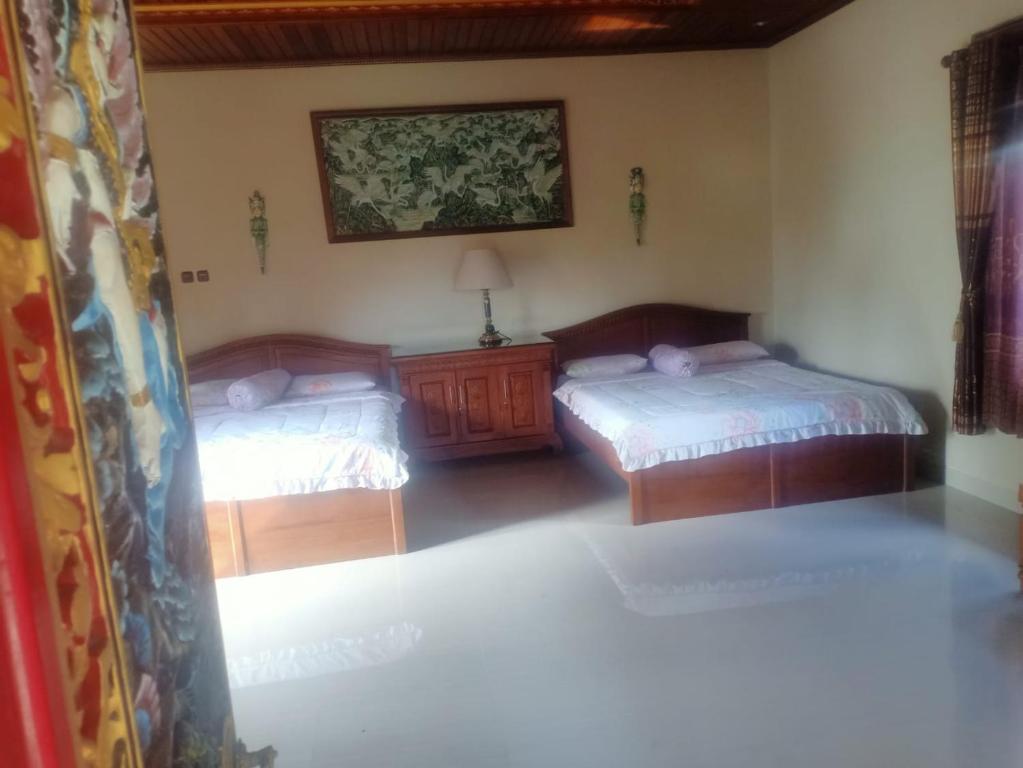 希德门普瑞阿贡酒店的一间卧室设有两张床,墙上挂着一幅画