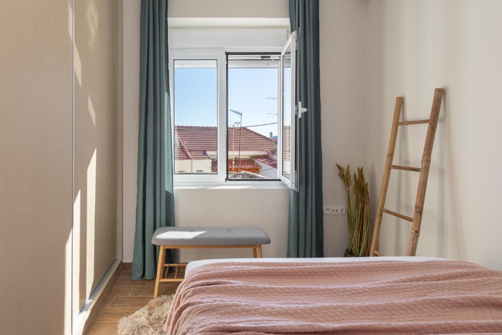 比雷埃夫斯Mikrolimano Gem: Serene 1BR Apartment的卧室配有床、椅子和窗户。
