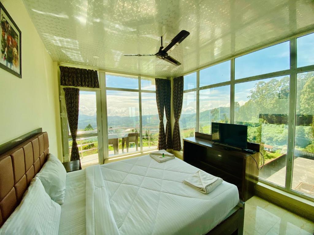 乌提Tulips Village Resorts的一间卧室设有一张床和一个大窗户