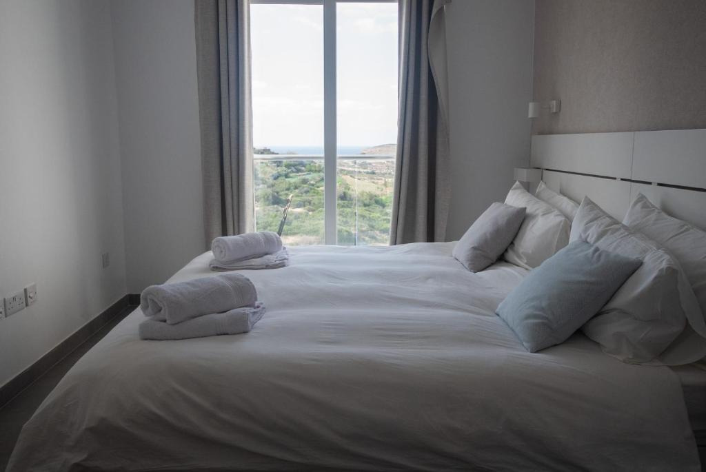 梅利哈Gest的一张带枕头和窗户的大型白色床