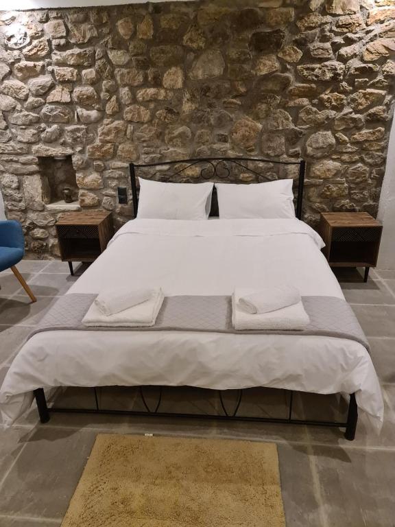卡拉维塔Villas Kertezi的一张大床,位于一个石墙房间内