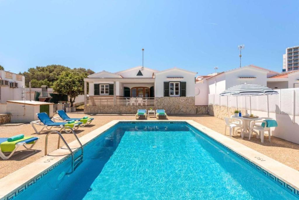 阿雷纳尔登卡斯特尔Villa Mar Azul的一个带椅子的游泳池以及一座房子