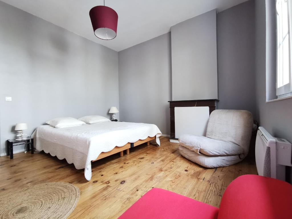 波尔多Logement vue Garonne的白色卧室配有床和椅子
