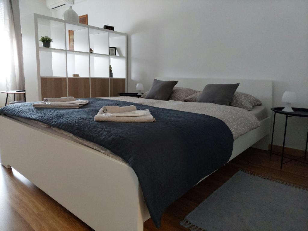 大戈里察M&M Apartment的一间卧室配有一张大床和两条毛巾
