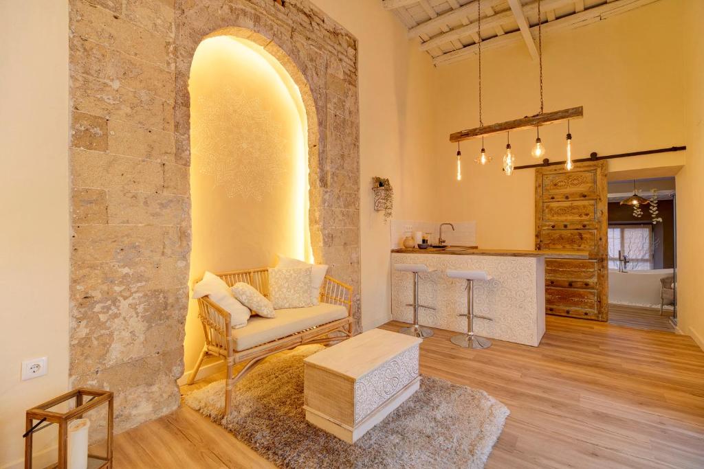 赫雷斯-德拉弗龙特拉Private Spa in Kangen House Jerez的客厅设有石墙和椅子