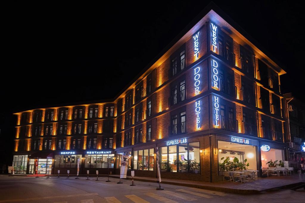 埃迪尔内WestDoor Hotel的建筑的侧面有蓝色的灯光