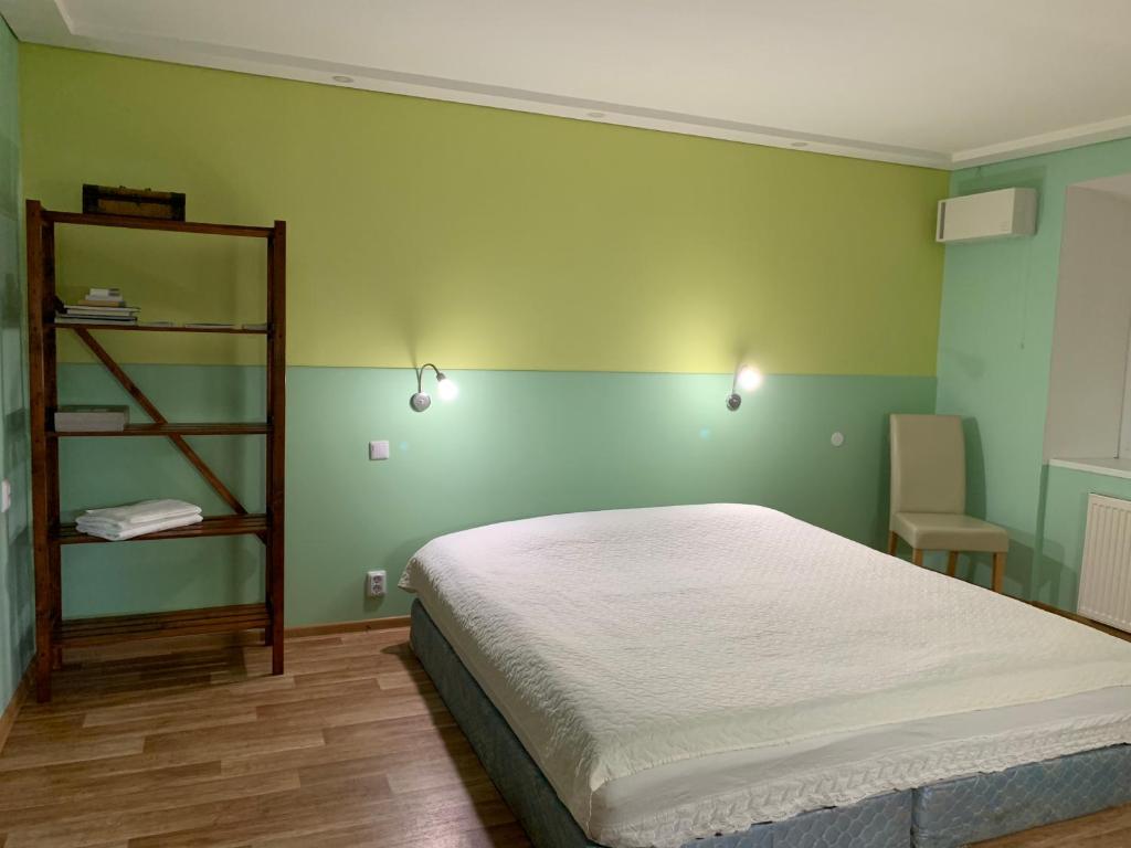 RamučiaiGreen house Ramuciai的一间卧室设有一张床和绿色的墙壁