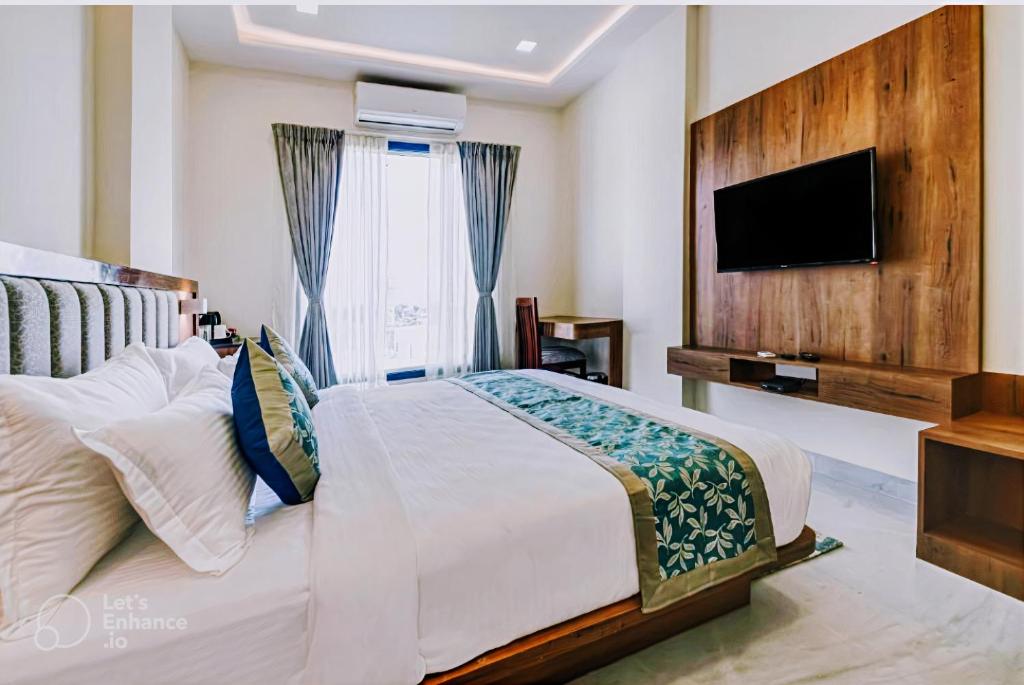 新德里Hotel De Hocks Deluxe - New Delhi的一间卧室设有一张大床和一台平面电视。