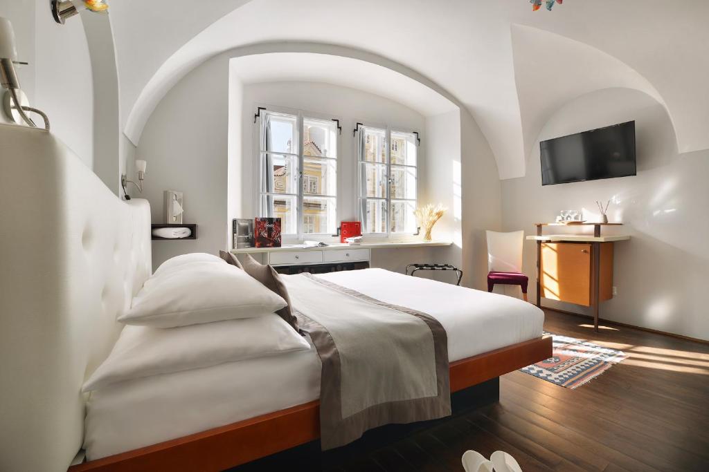 布拉格设计聂鲁达酒店的卧室配有床和盥洗盆