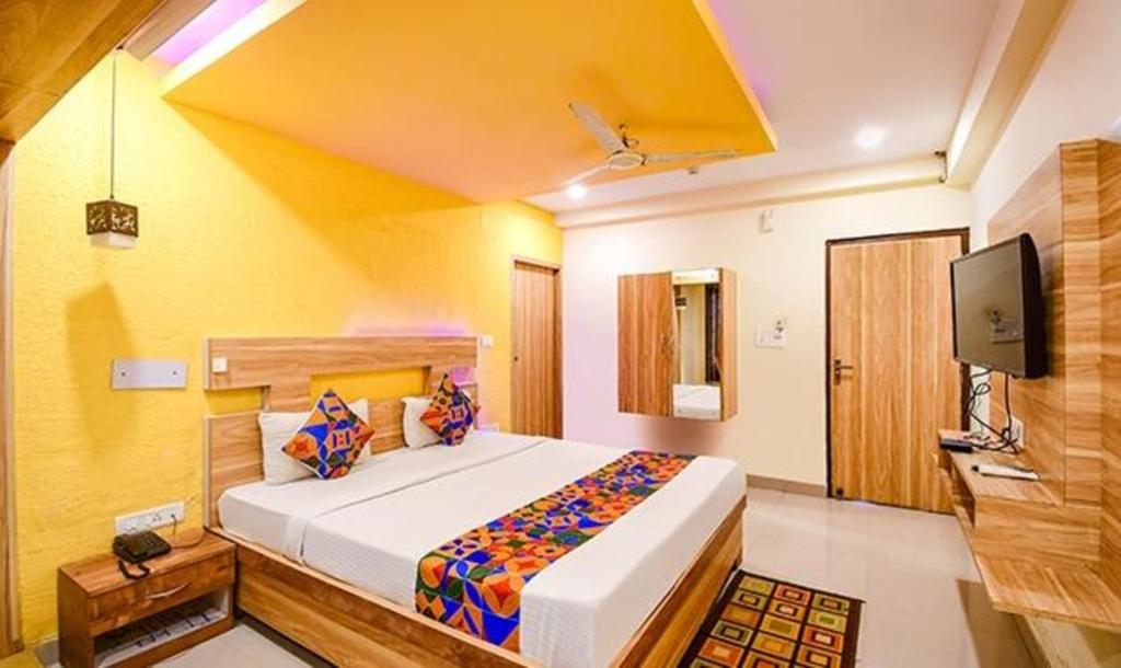 KhandagiriFabHotel Sai Jagannath Residency的一间带大床和电视的卧室