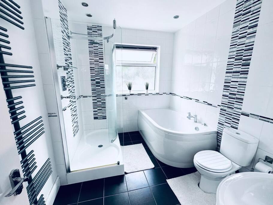 诺丁汉Comfy House Near The City Centre的白色的浴室设有浴缸、卫生间和水槽。