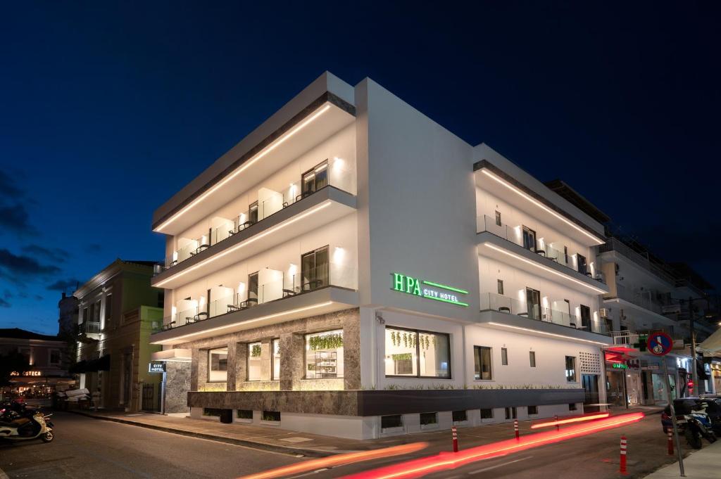 卡拉马塔IRA - ΗΡΑ City Hotel的夜行在城市街道上的白色建筑