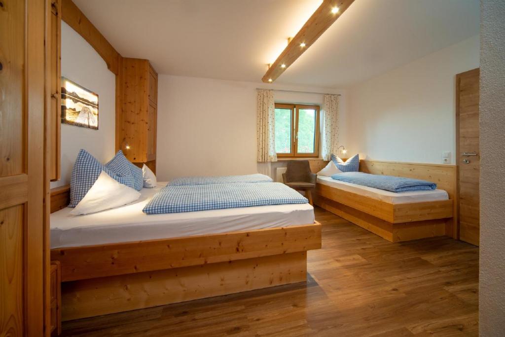 霍普费劳Panoramablick Heimen的一间卧室配有两张带蓝色枕头的床