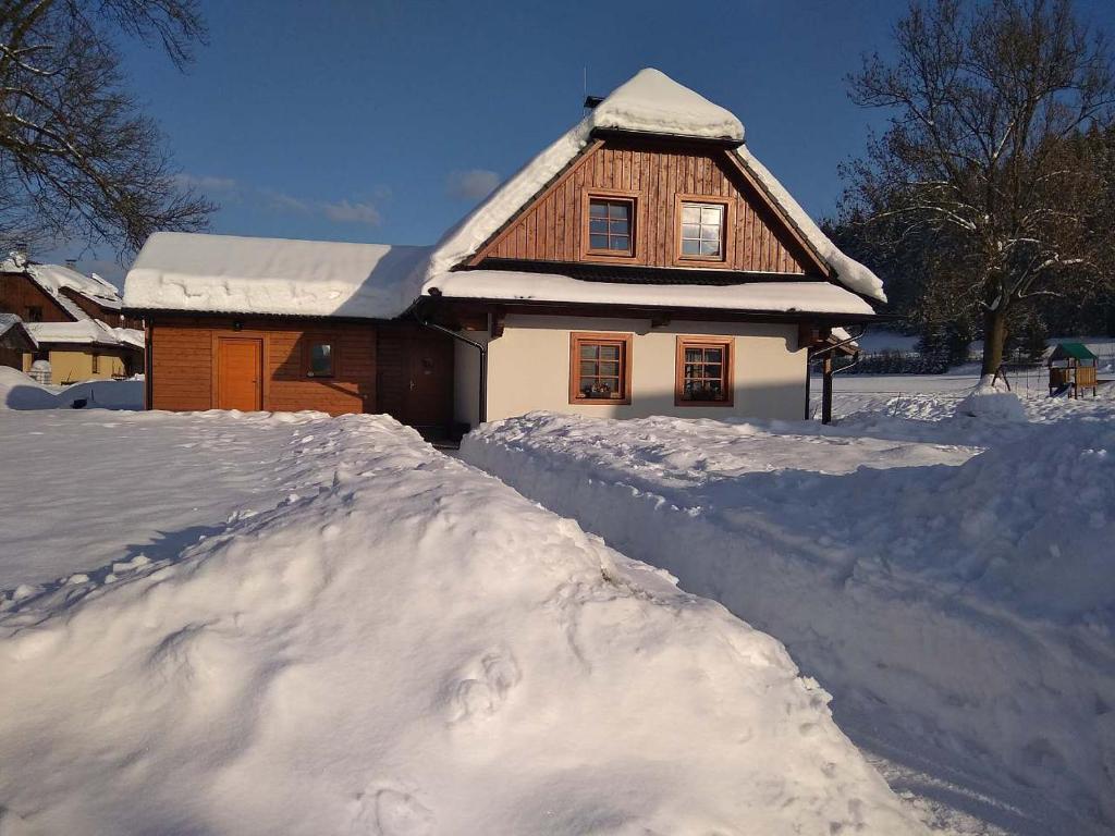 大卡尔洛维采Valachy chalupa Velké Karlovice的前面有一堆积雪的房子