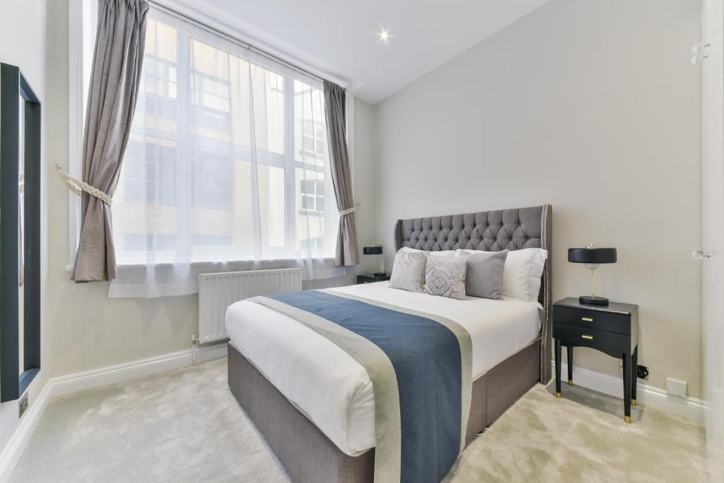 伦敦Avari Apartments - Hatton Collection的一间卧室设有一张大床和一个窗户。