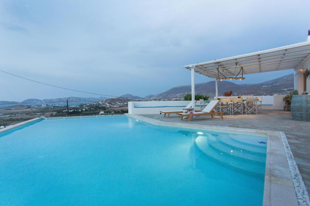 帕罗奇亚Luxury Private Family Villa with Private Infinity pool的一个带桌椅的大型蓝色游泳池