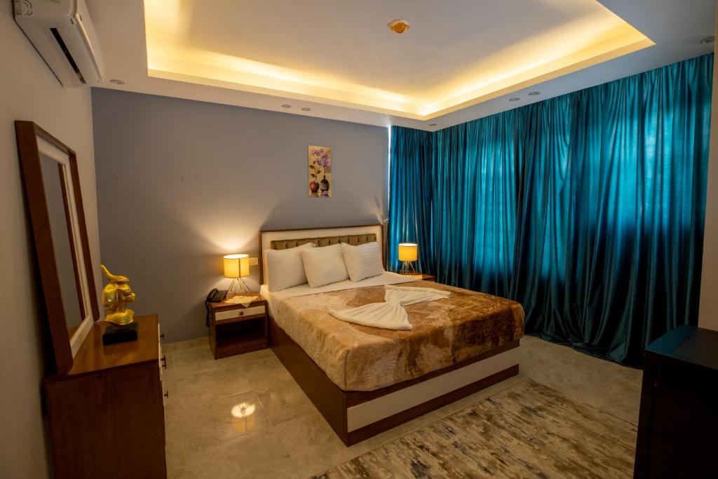 开罗El Shams Plaza Hotel的一间卧室配有一张带蓝色窗帘的大床