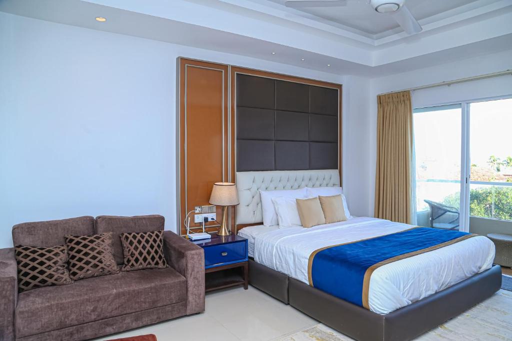 尼甘布Ocean Breeze Studio Apartment Negombo的一间卧室配有一张床、一张沙发和一把椅子