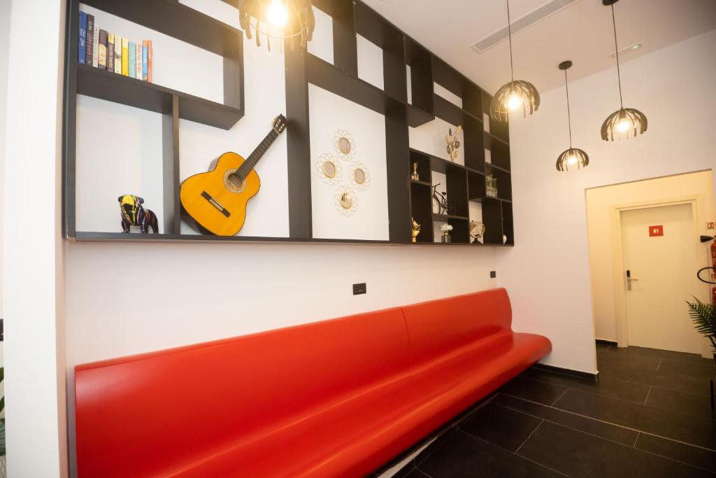 斯利马Citizen Suites的墙上有吉他的房间的红色沙发