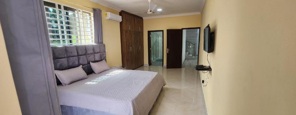 AdentanJab Duplex X的一间卧室设有一张床、一个窗口和一台电视